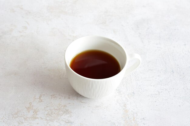 Una taza de café se sienta en una mesa de mármol copia espacio aislado