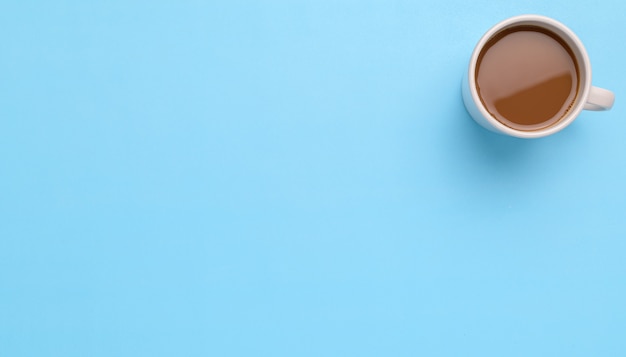 Taza de café sobre un fondo azul.