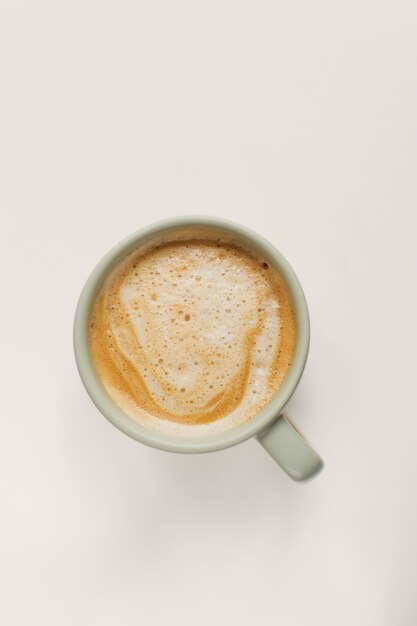 Taza con café sobre un fondo blanco.