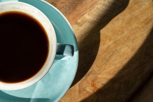 Taza de café sobre fondo de escritorio de madera, plano, de cerca.