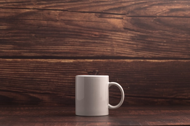 Taza de café sobre fondo de madera oscura.