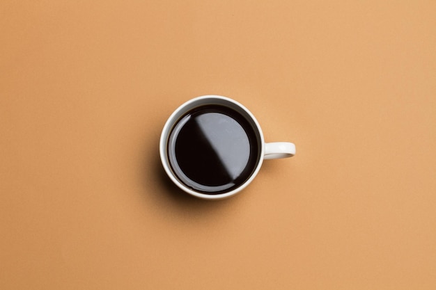 Taza de café sobre un fondo marrón en una vista superior