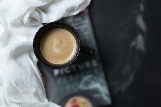 Taza de café sobre libro Enfoque selectivo