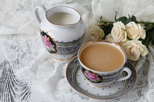 Taza de café sobre una mesa con flores.