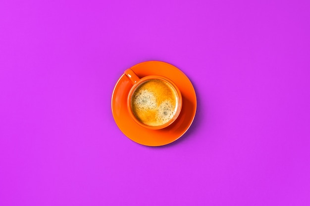Una taza de café sobre la mesa púrpura.