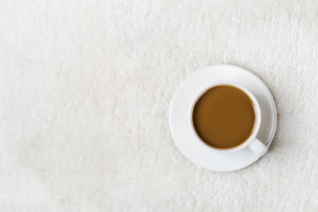 Taza de café sobre pelaje blanco. Otoño o invierno mínimo acogedor fondo.