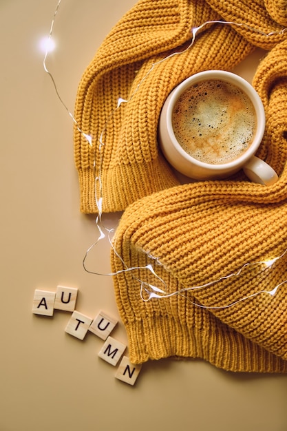 Taza de café y suéter amarillo.