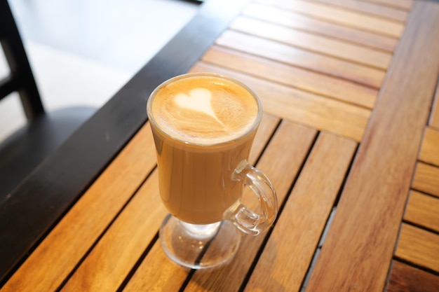 Una taza de café tardío con un diseño en forma de flor en la parte superior del café