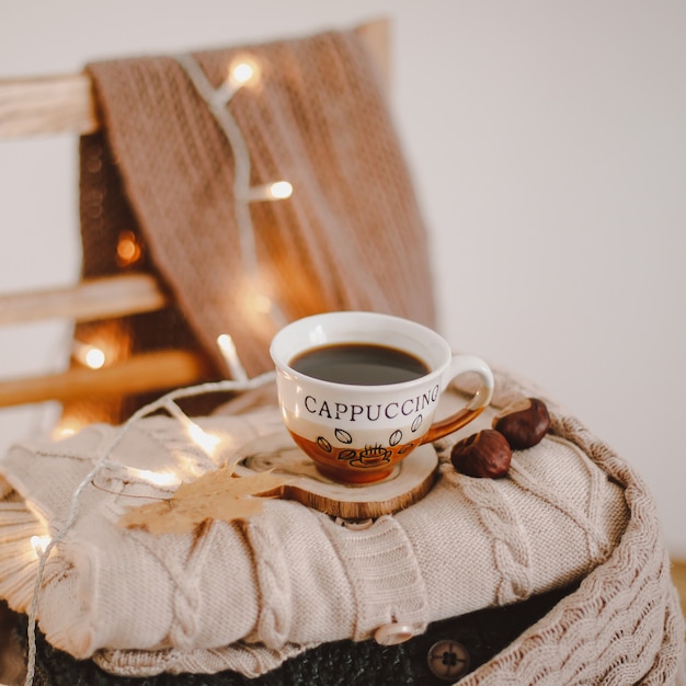 una taza de café en una tela escocesa beige tejida con luces bokeh