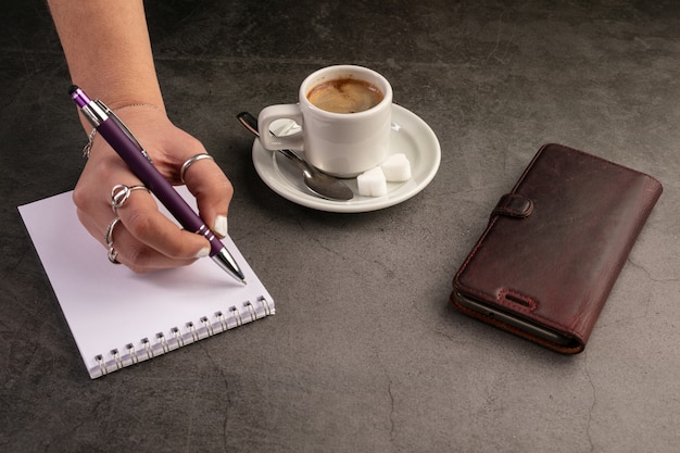 Taza de café con teléfono y cuaderno