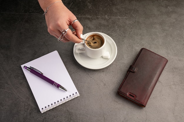 Taza de café con teléfono y cuaderno