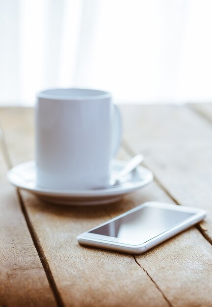 Taza de café y teléfono inteligente.