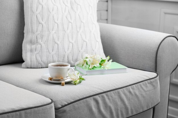 Foto taza de café con terrones de azúcar y flores en el sofá