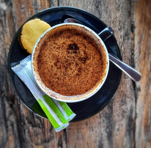 una taza de café con un trozo de pan al lado.