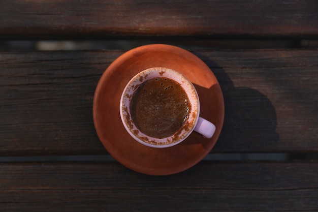 Taza de café turco de arcilla auténtica en la vista plana de la mesa de madera vista superior