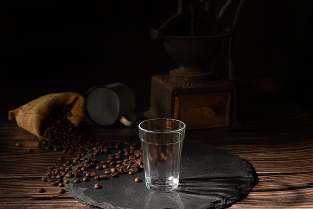 Taza de café vacía y granos de café en una piedra gris sobre madera estilo comida oscura foto enfoque selectivo