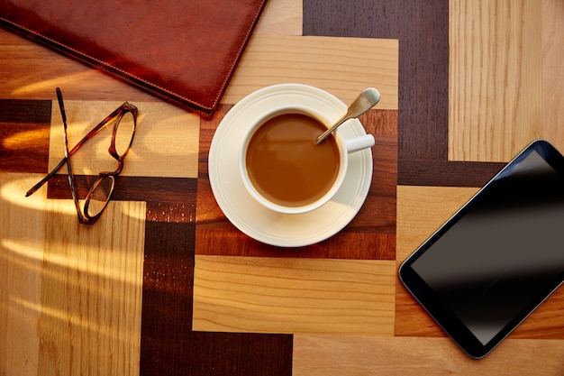 Taza de café con vasos y tablet pc.