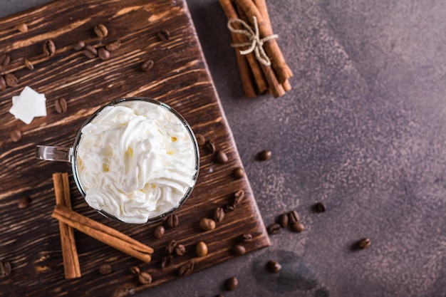 Taza de café vienés con crema batida y canela en la vista superior de la mesa