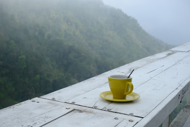 Foto taza de café con vista a la colina en el fondo