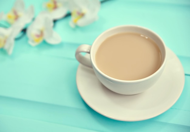 Taza de café en la vista superior de la mesa de madera antigua con flores frescas de primavera