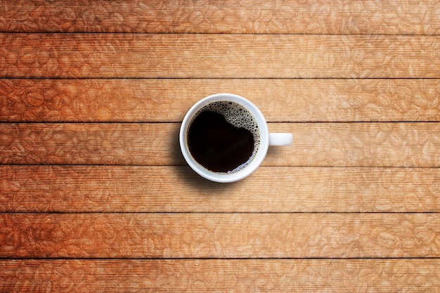 Taza de café en la vista superior de la mesa de madera