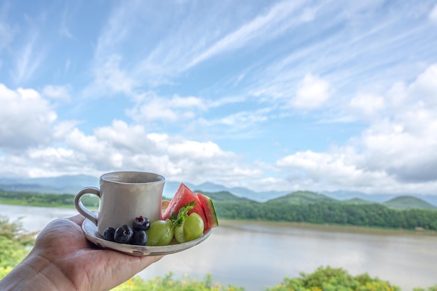 Una taza de café con vistas a las montañas de fondo.