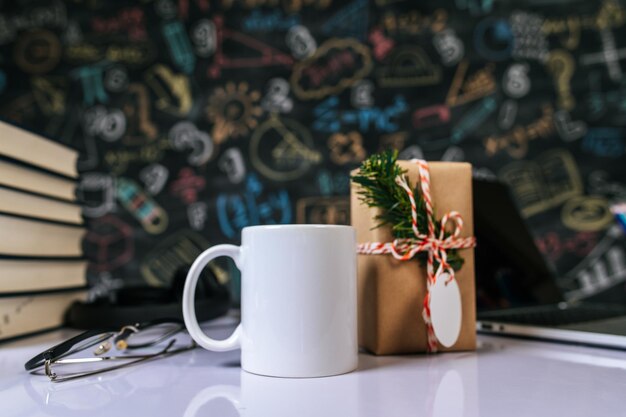 la taza y la caja de regalos en la mesa en el aula