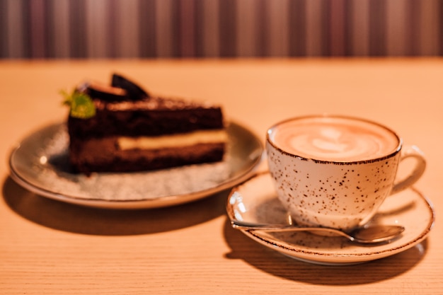 Una taza de capuchino aromático está sobre una mesa en un café