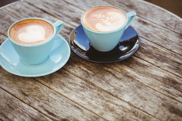 Taza de capuchino con café en la mesa de madera en la cafetería.