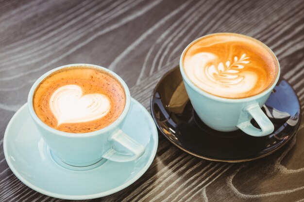 Taza de capuchino con café en la mesa de madera en la cafetería.