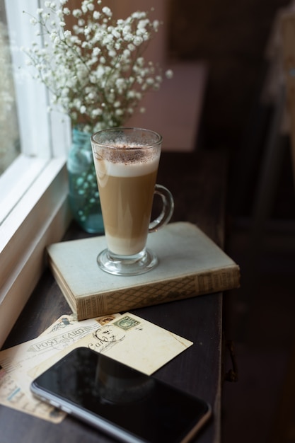 Taza de capuchino delante de una ventana