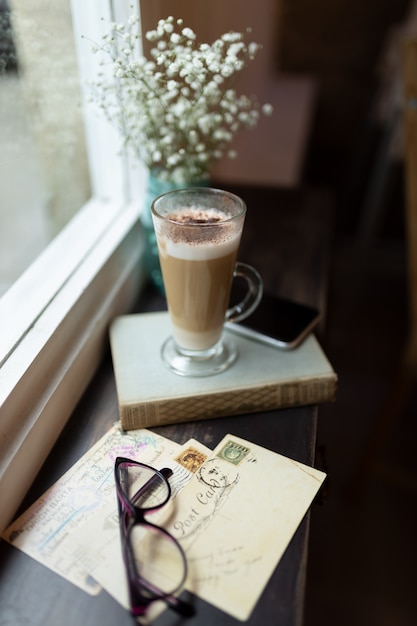 Taza de capuchino delante de una ventana