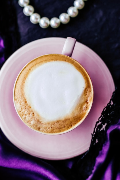 Taza de capuchino para el desayuno con fondo de joyería de satén y perlas café orgánico con leche sin lactosa en un café parisino para una lujosa marca de vacaciones vintage