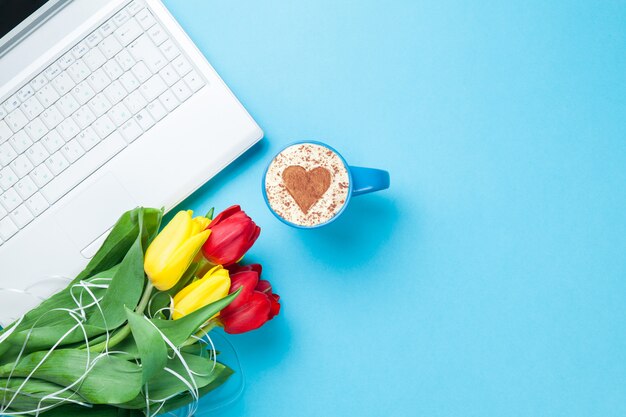 Taza de capuchino con forma de corazón y computadora