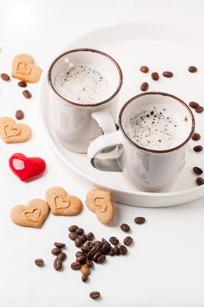 Taza de capuchino con galletas como corazones