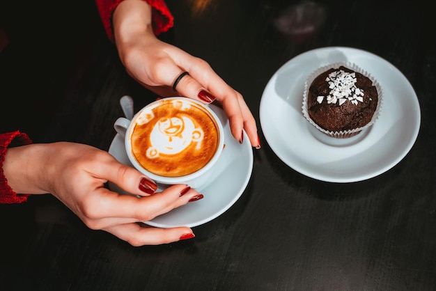 Taza de capuchino en manos