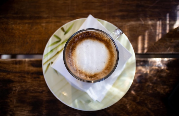 Foto una taza de capuchino en la mesa de madera aislada y vista superior