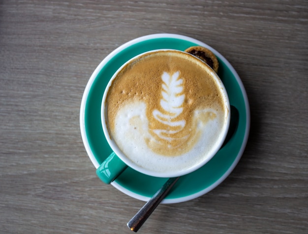 Taza de capuchino en la mesa de madera marrón