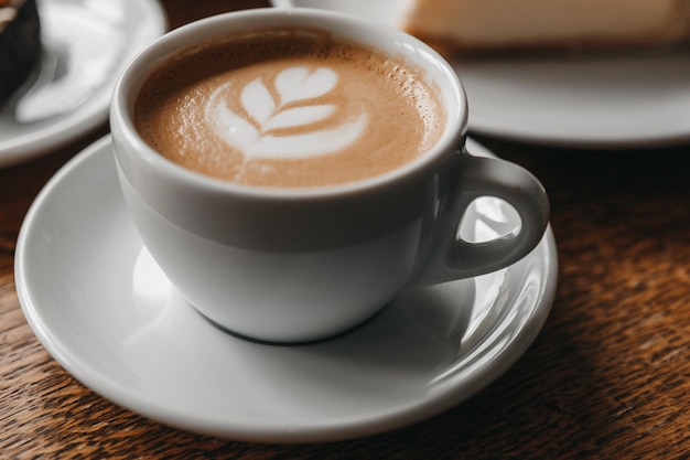 Una taza de capuchino en una mesa de madera.