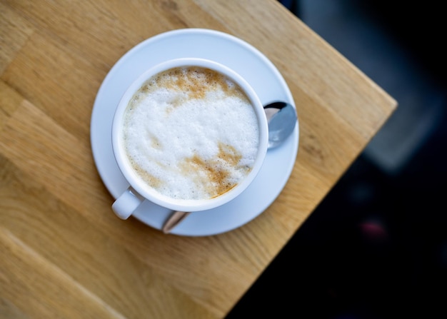 taza de capuchino en la mesa de madera