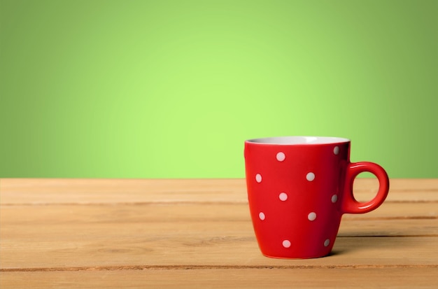 Taza de cerámica roja sobre mesa de madera