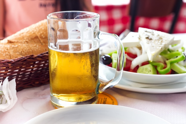 Taza con cerveza en el fondo de un café de la calle exterior