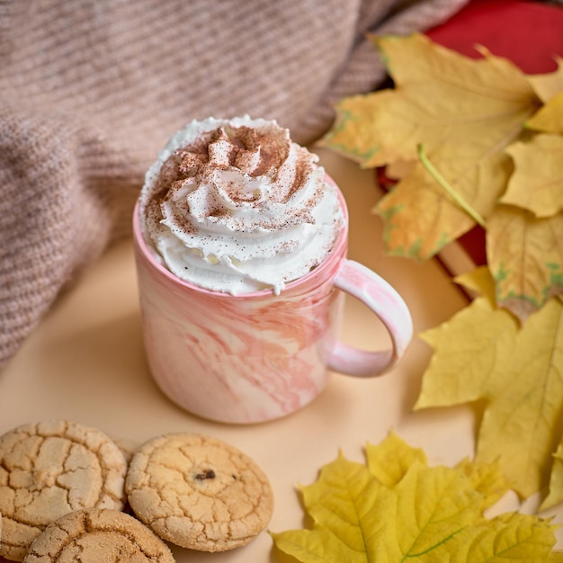 Taza de chocolate caliente con crema en otoño caen hojas con arte latte, vista superior.