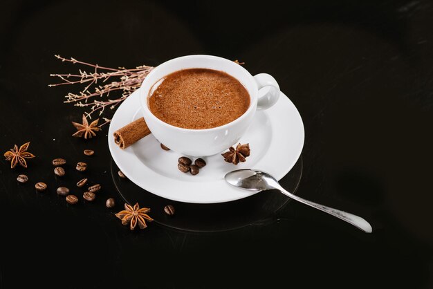 Una taza de chocolate caliente con ingredientes de fondo negro