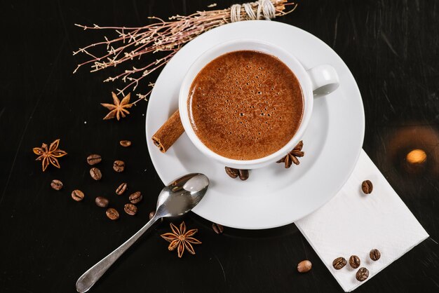 Una taza de chocolate caliente con ingredientes de fondo negro