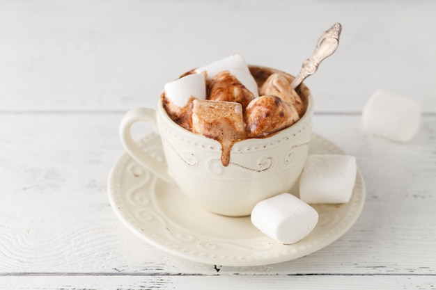 Taza de chocolate caliente con malvaviscos en la mesa