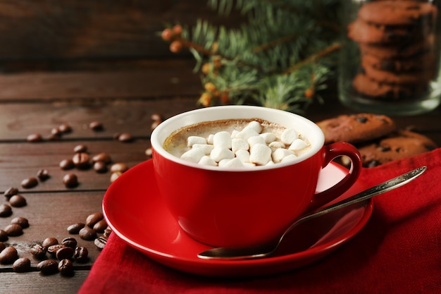 Taza de chocolate caliente con malvaviscos, rama de abeto sobre fondo de madera