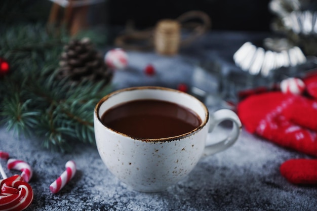 Taza de chocolate caliente o cacao y variedad de dulces navideños Acogedora decoración de vacaciones de invierno y enfoque selectivo de abeto