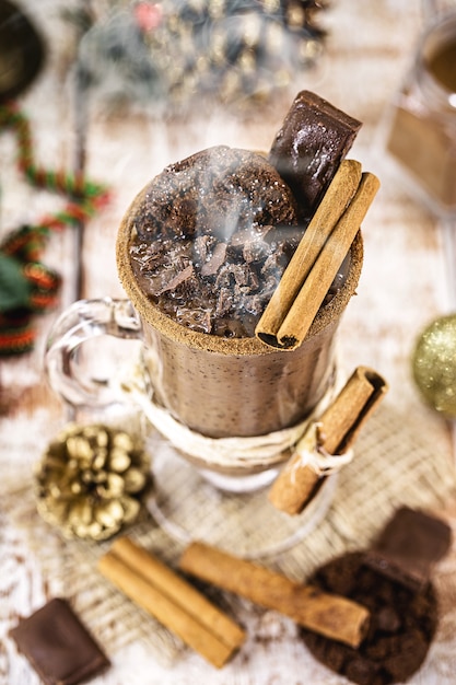 Taza de chocolate caliente con temática navideña, bebida típica de las fiestas. Foco en canela