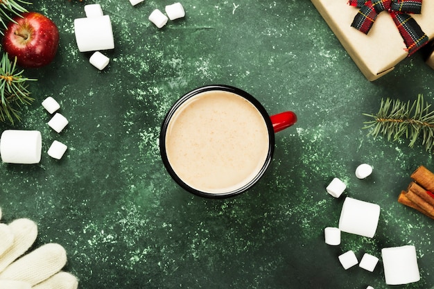 Taza de chocolate caliente y varios atributos de vacaciones en gris, vista superior